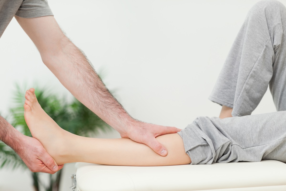 Close-up of the leg of a woman being stretched in a room